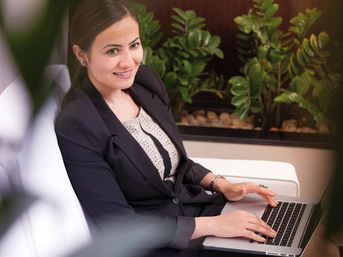 Movenpick Jumeirah Village Triangle Dubai Buitenkant foto A business woman working on a laptop